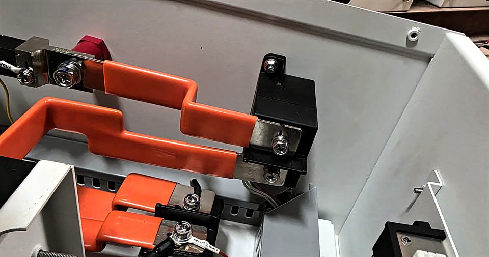 Barres de raccordement orange et connecteurs dans une armoire blanche
