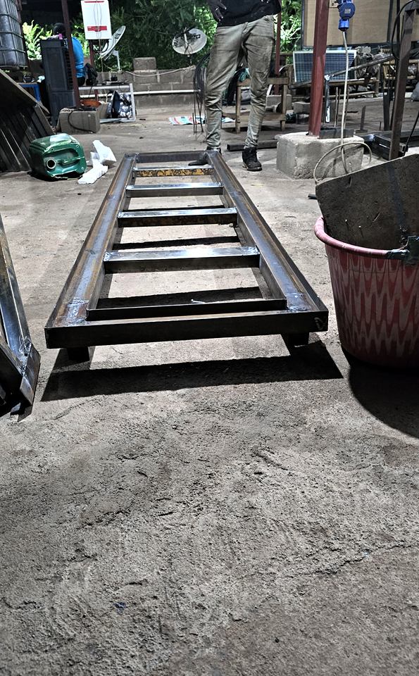Châssis métallique en forme d'échelle posé sur une dalle de béton