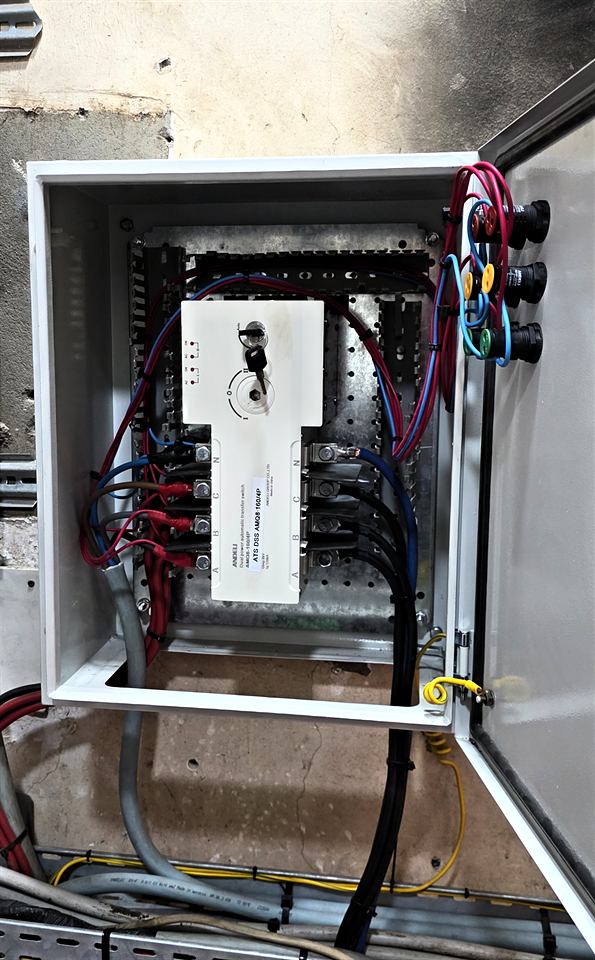 Coffret électrique ouvert avec câbles rouges et noirs raccordés
