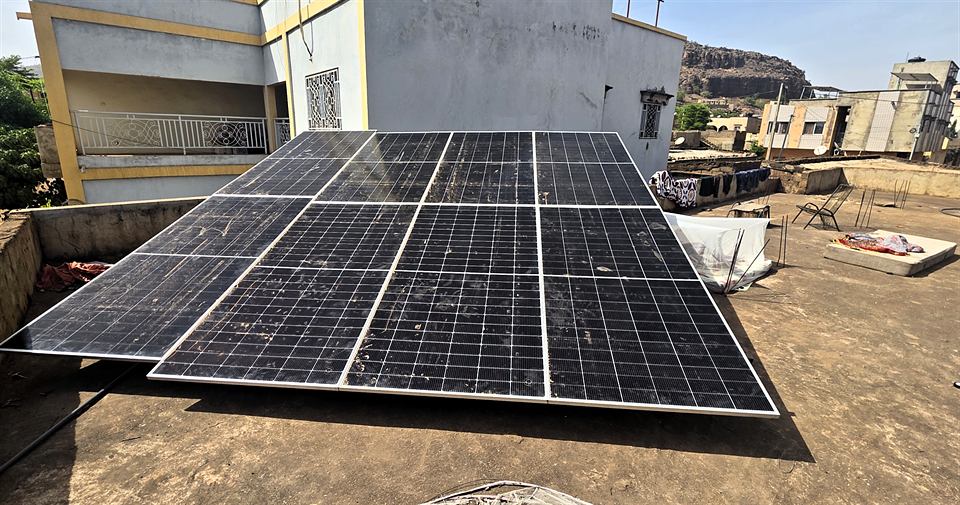 Modules solaires posés sur une terrasse, bâtiments voisins en arrière-plan