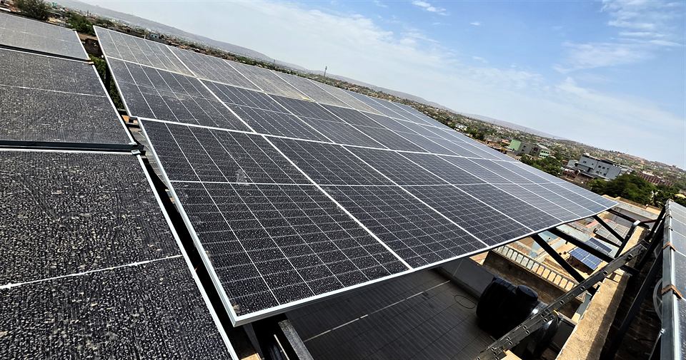 Vue large de modules solaires inclinés sur une toiture, ciel dégagé
